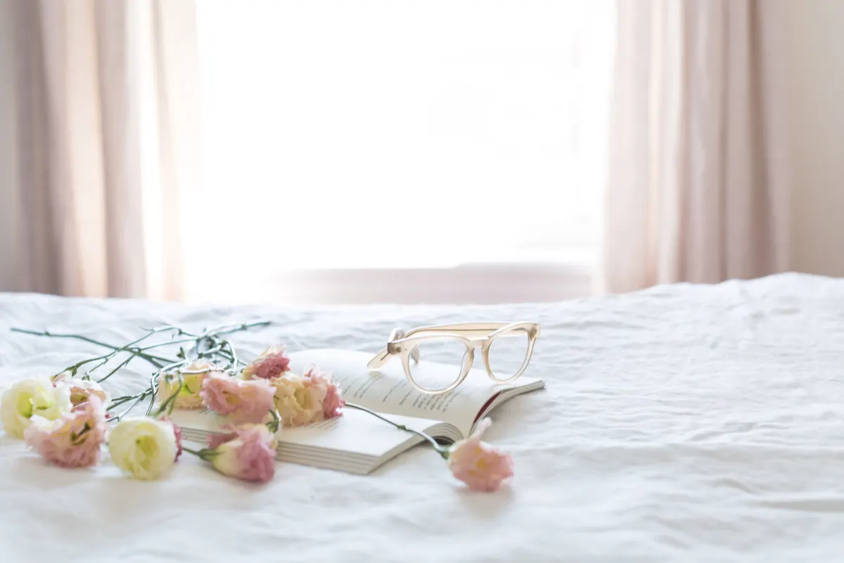 A pair of glasses resting on an open book